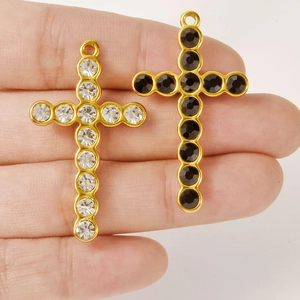 304 stainless steel cross pendants with white and black crystals held in hand