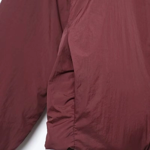 Detalle del bolsillo lateral y la textura de la tela rojo vino en la chaqueta kimono