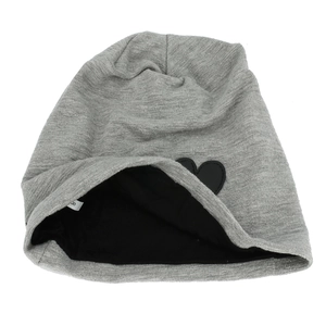 Close-up of grey knitted beanie featuring a black heart patch and soft inner lining