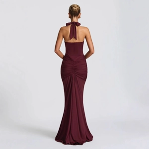 Detail of burgundy backless halter dress showing large bow and ruched fishtail hem