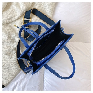 Internal view of blue tote bag showing the main compartment and contrast nylon strap