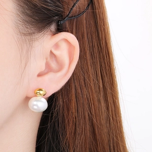 Elegant French-style gold pearl earrings shown on a model with a side profile view