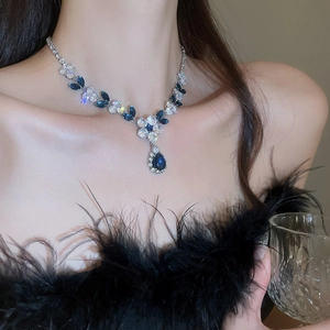 Close-up of zircon floral necklace with deep blue stones worn by a model