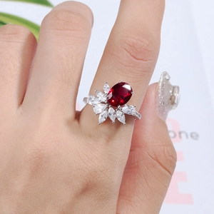 Macro view of S925 silver ring featuring an oval red gemstone and white marquise cut zircons