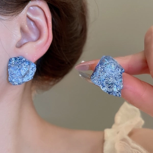 Detailed view of blue irregular resin stud earring featuring sparkling crystalline textures