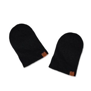 Black ribbed knit beanie set with star embossed faux leather patch in a flat lay view