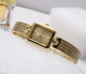Detail of square gold quartz watch face with luxury zircon encrusted bracelet link