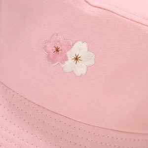 Close-up of pink cotton bucket hat with detailed cherry blossom embroidery and stitching