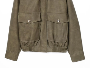Détail d'une veste en daim vert olive avec poches cargo et boutons en métal rétro