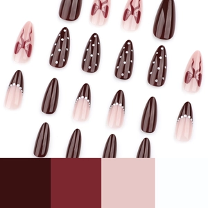 French bow press-on nails in chocolate brown and pink almond shape with dots