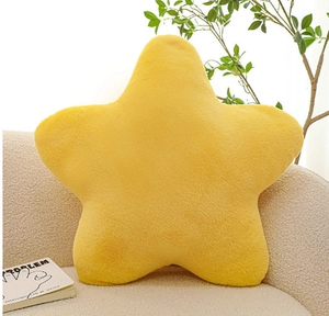 Close-up of a soft yellow star-shaped plush pillow on a beige sofa in a cozy home setting