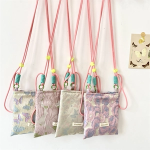 Detail of four colorful floral and butterfly jacquard crossbody phone bags with adjustable cords