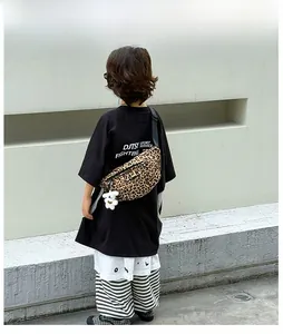 Detail of trendy leopard print canvas chest bag for kids with white teddy bear pendant
