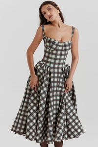 Macro detail of red and green plaid dress with corset style bodice and pleated hem