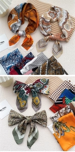 Macro shot of assorted printed silk scarves tied in bows on a wooden display