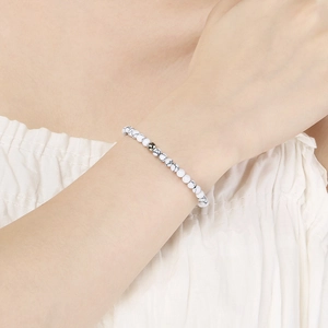 Gros plan d'un bracelet en perles de pierre marbrée blanche avec des détails en argent