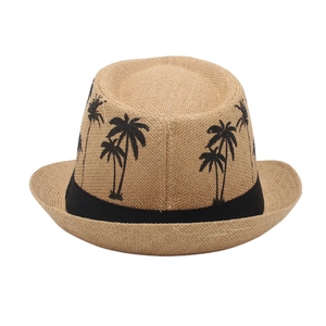 Detailed close-up of woven straw Panama hat featuring black palm tree embroidery and band