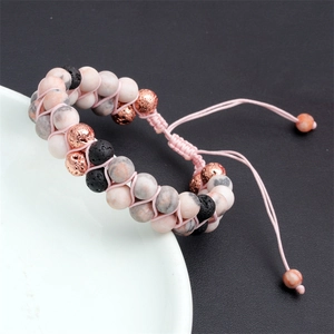 Dettaglio del bracciale regolabile con perle di marmo rosa e pietre di lava nera