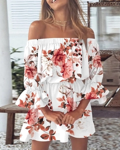 Detail van off-shoulder bloemenjurk met ruches aan de mouwen en oranje bloemenpatroon