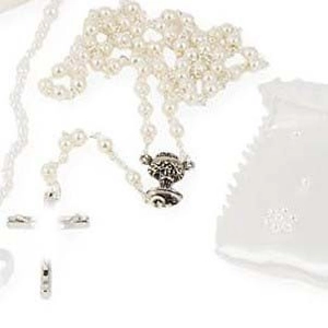 Vue détaillée du chapelet en perles blanches avec croix en argent et pochette de rangement