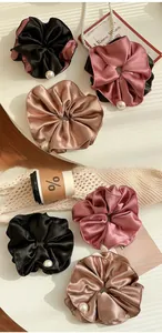Detail of satin pearl hair scrunchies in black, pink and champagne colors