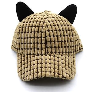 Detail of camel textured corduroy baseball cap featuring cute black plush cat ears