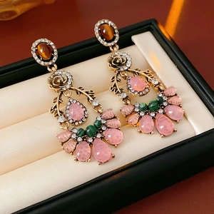 Detail of vintage gold flower earrings with pink water drop gems and sparkling rhinestones