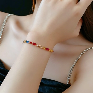Close-up of gold-plated bracelet featuring colorful rectangular zircons on model wrist