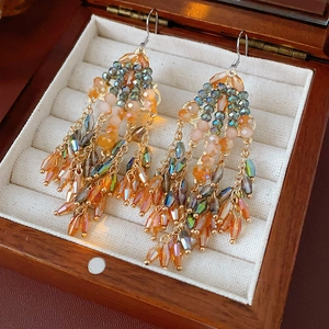 Macro view of vintage bohemian glass tassel earrings with colorful beads on a jewelry box