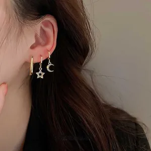 Detail of gold plated six-piece earring set featuring zircon star and moon charms