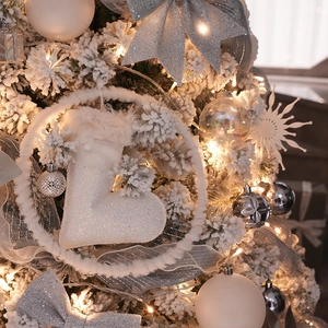 Sparkling white glitter boot ornament with faux fur trim on a snow-covered Christmas tree