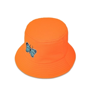 Détail de la broderie papillon bleu sur le tissu en sergé de coton du chapeau bob orange