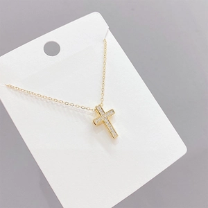 Collar de cruz chapado en oro para mujer con circonitas brillantes sobre fondo gris