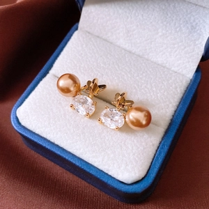 Vue macro des boucles d'oreilles papillon plaquées or 18K avec cristal et perle
