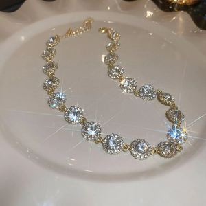 Vue détaillée d'un collier doré étincelant avec zircons blancs sur une plaque en céramique