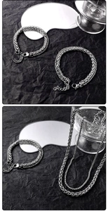 Detail of silver double-layer titanium steel chain bracelet and necklace on dark background
