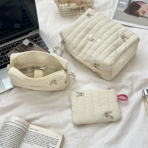 Detailed set of three quilted rabbit embroidered organizer bags in cream stripe fabric