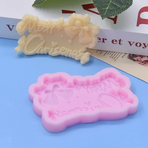 Close-up of pink silicone mold with Merry Christmas text and bell pattern for DIY