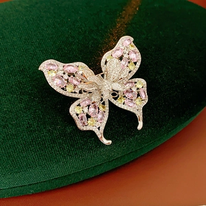 Macro shot of silver-plated butterfly brooch with sparkling pink and yellow zircons