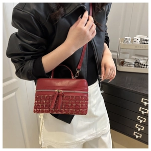 Detail of red tweed box bag with PU leather trim and metal zipper worn by a model