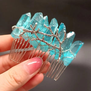 Nahaufnahme von blauen Rohkristallen auf einem silbernen Metallzweig-Haarkamm für Stylings