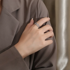 Macro detail of silver pavé-set link ring with sparkling zircons on female hand