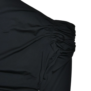 Détail macro d'une manche de body noir avec coutures froncées et texture élastique
