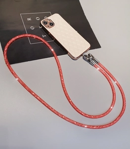 Detail of pink glitter phone lanyard with metal clasps on a white quilted case