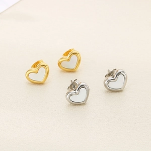 Dettaglio di orecchini a cuore con inserto in conchiglia in acciaio oro e argento