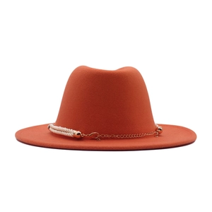Détail d'un chapeau en feutre orange avec corde blanche et chaîne en métal doré chic