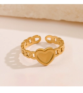 Detailed view of the gold heart chain ring on a textured stone surface, minimalist style