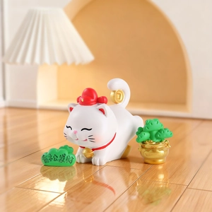 Détail de figurine chat de la fortune blanc avec pièces d'or et feuille de pin décorative