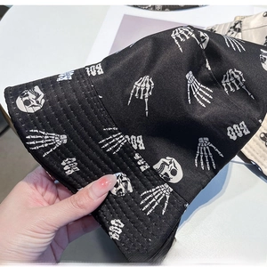 Detail of black canvas bucket hat with white skull patterns and BOO text print