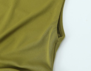 Dettaglio cuciture e tasca laterale su un abito lungo in maglia verde oliva